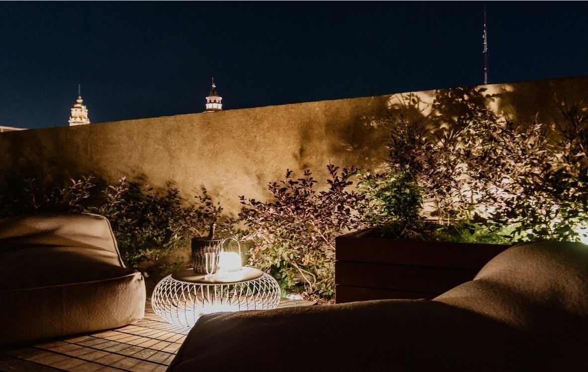Un patio con un sofá y una mesa por la noche.