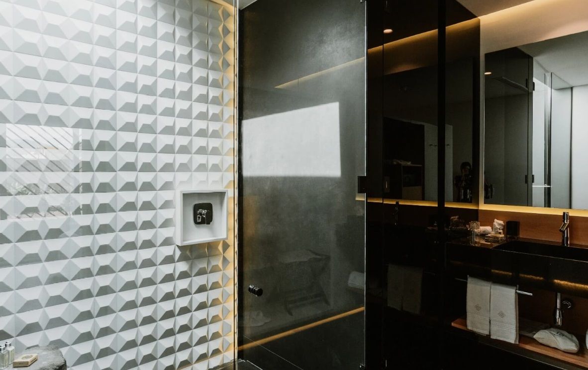 Un baño con ducha, lavabo y espejo.