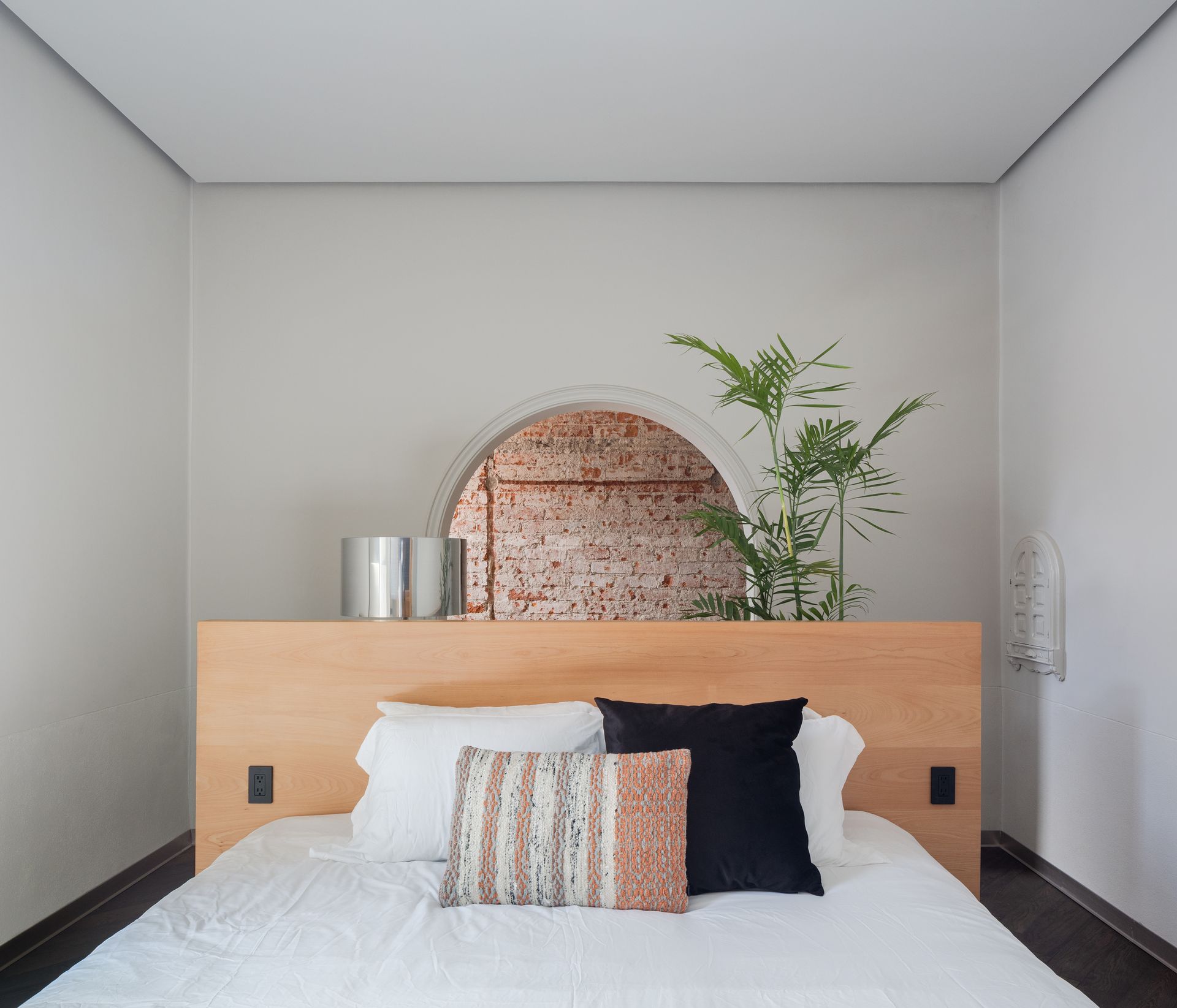 Un dormitorio con una cama y un cabecero de madera.