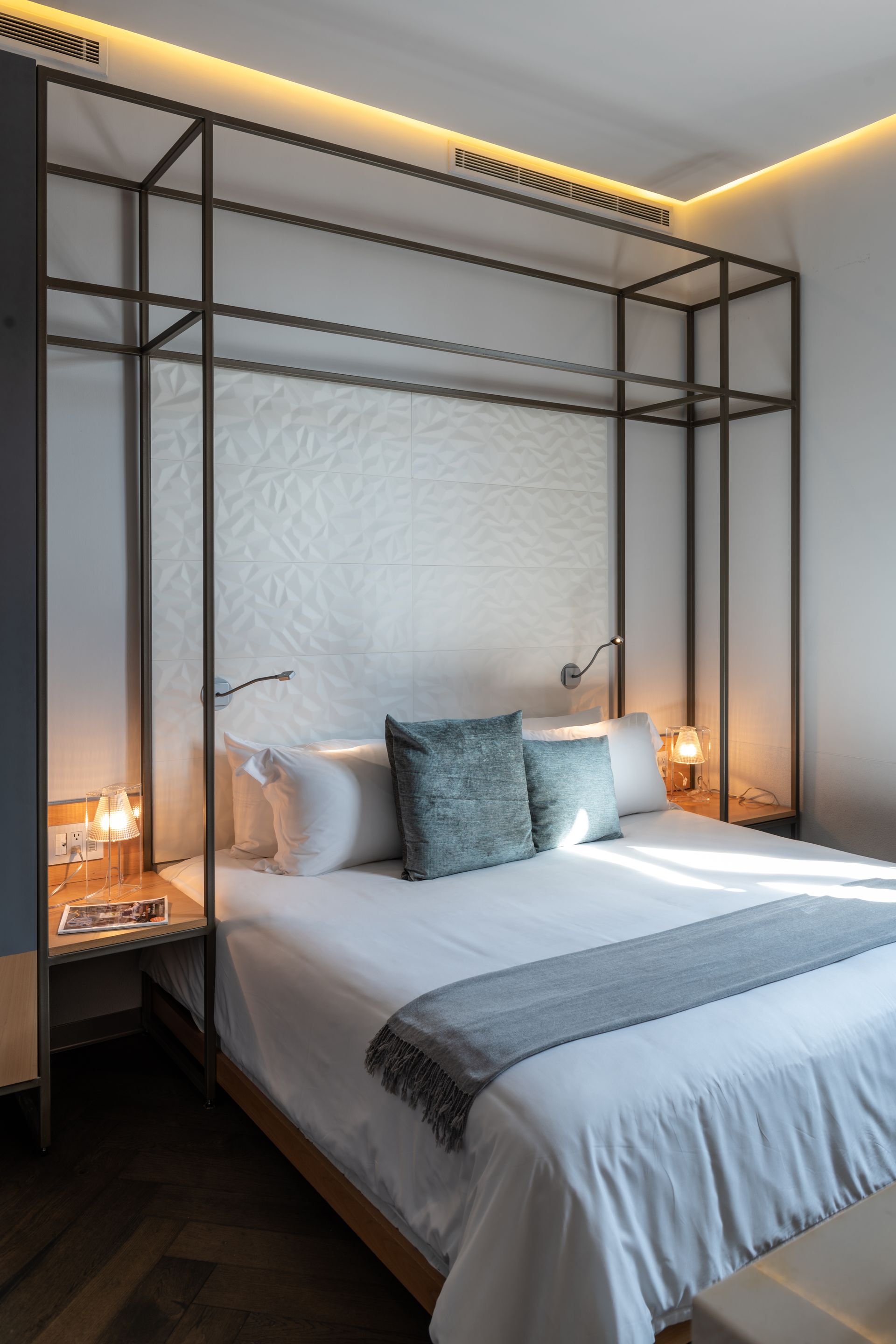 Un dormitorio con una cama con dosel y dos mesitas de noche.