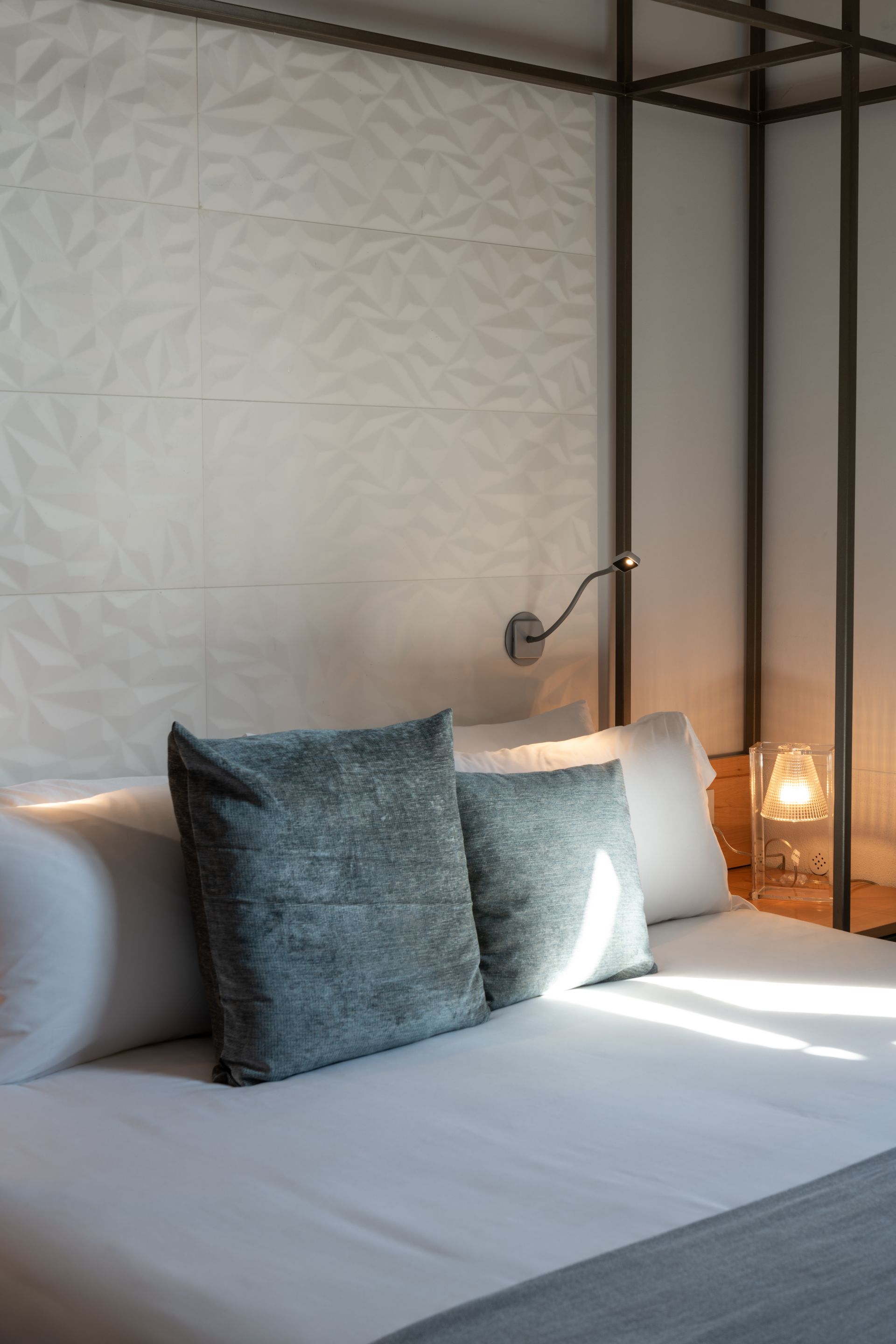 Una cama con dosel y almohadas en una habitación de hotel.