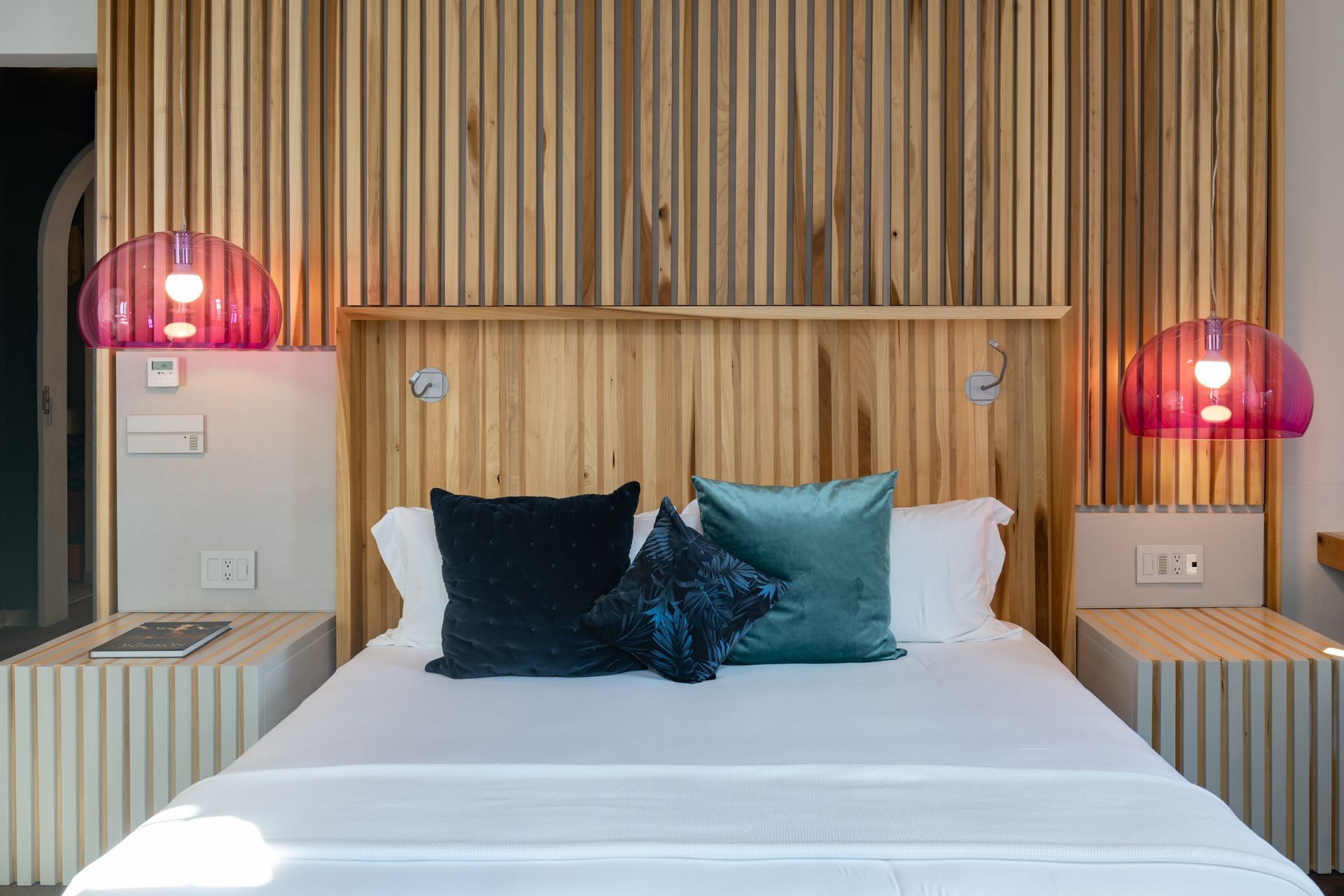 Una cama con cabecero de madera y almohadas en un dormitorio.