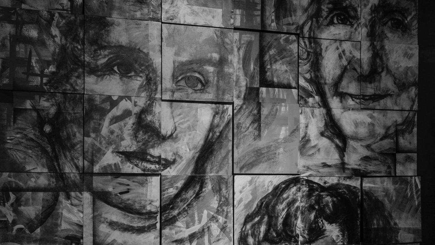 Una pintura en blanco y negro del rostro de una mujer en una pared.