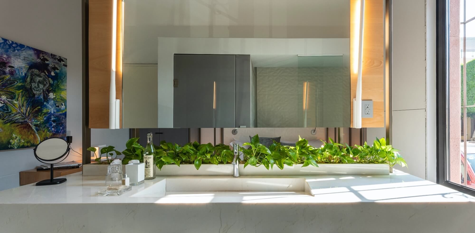 Un baño con un gran espejo y un lavabo.