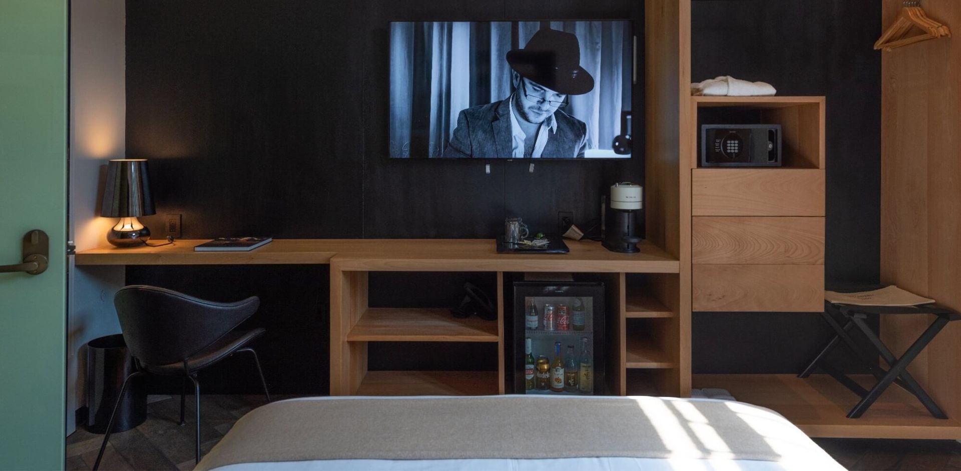 Una habitación de hotel con cama, escritorio, silla y televisión.