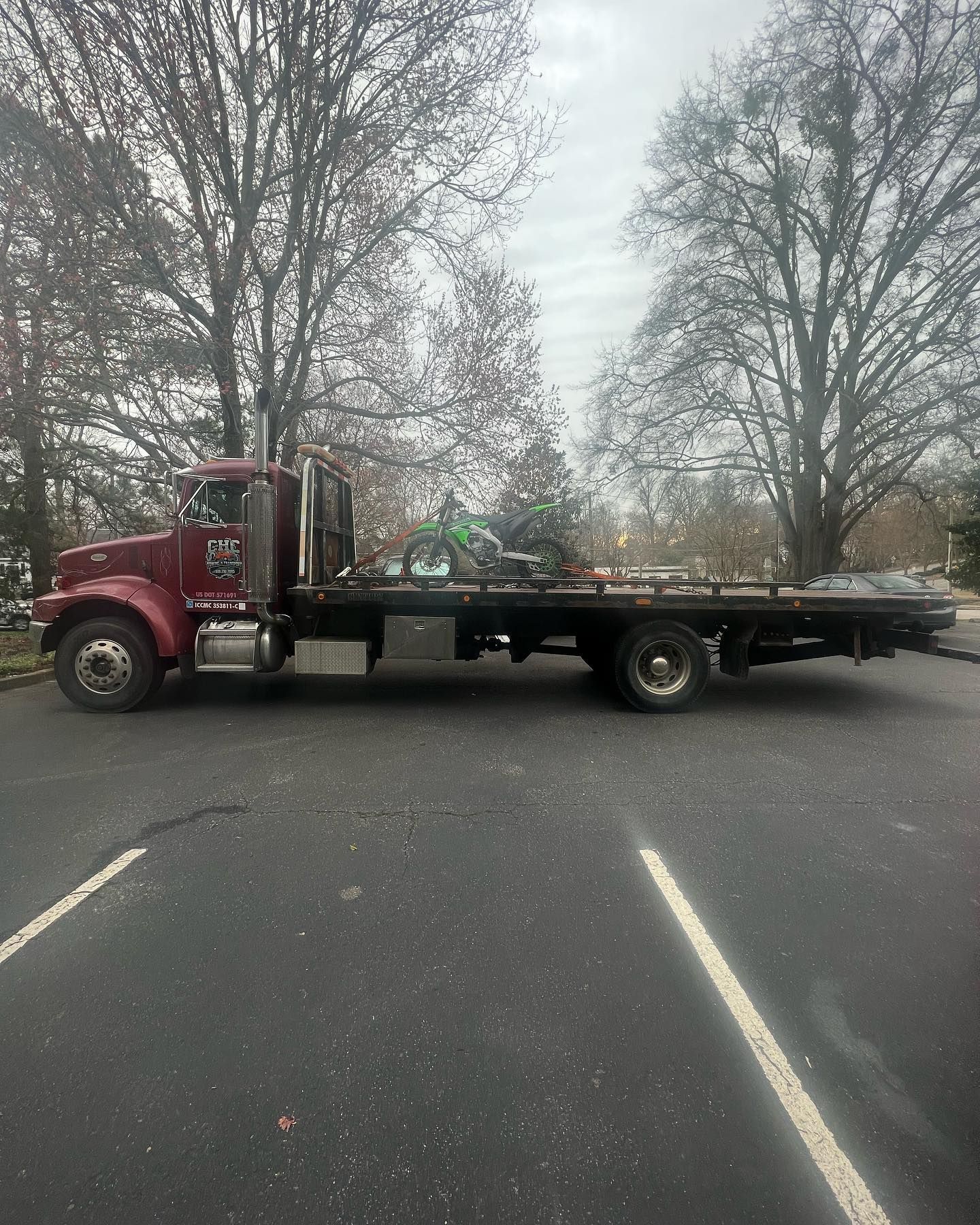 A red tow truck is parked in a parking lot.