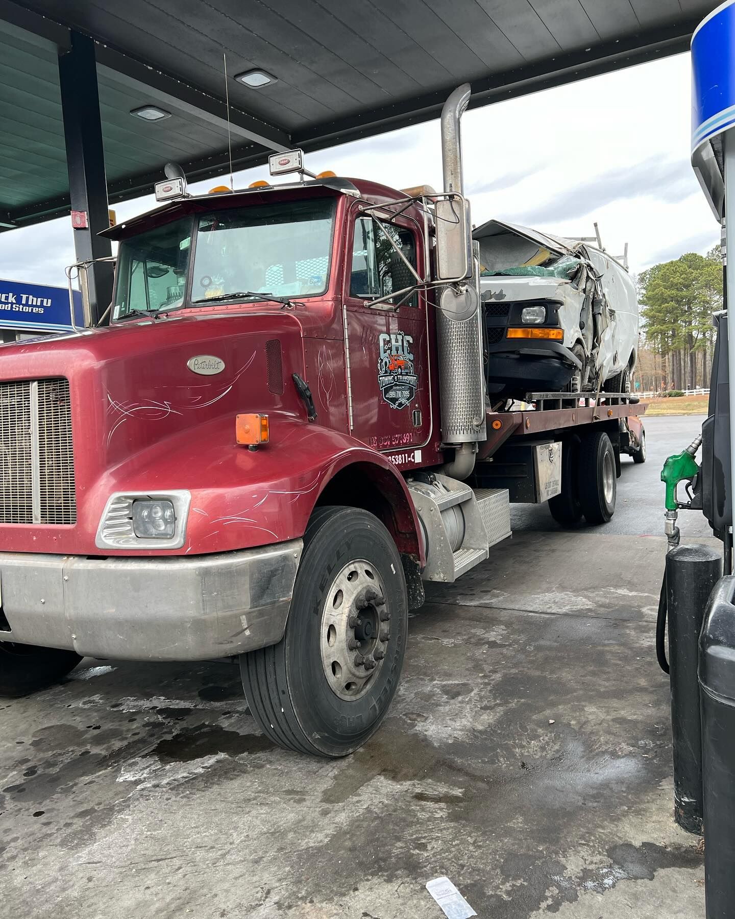 A red tow truck is parked at a gas station.