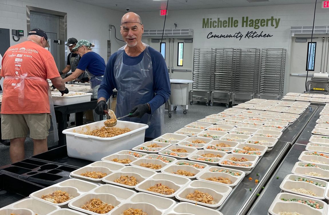 volunteer packing meals in two-department meal containers in the michelle hagerty community kitchen at palm beach county food bank
