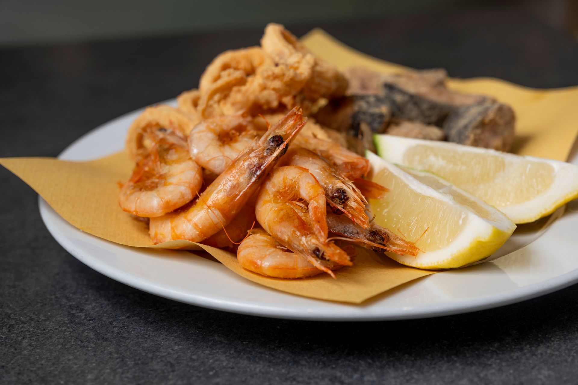 Piatto di frutti di mare fritti con spicchi di limone.