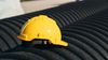 Yellow hard hat resting on dark corrugated surface