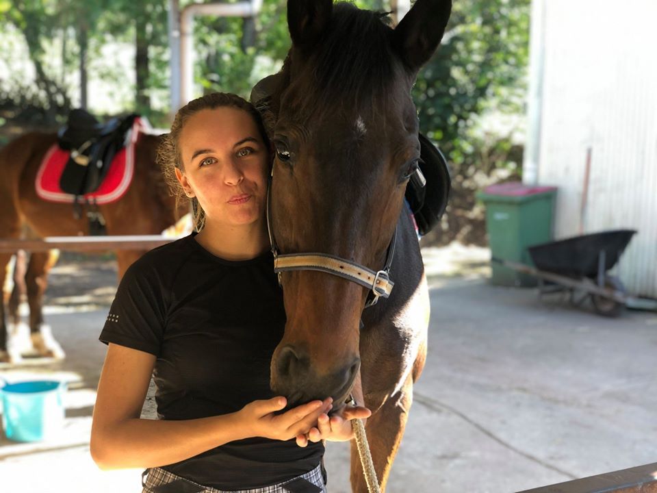 A Woman Is Standing Next To A Brown Horse — Merrypark Equestrian Centre In Eumundi, QLD