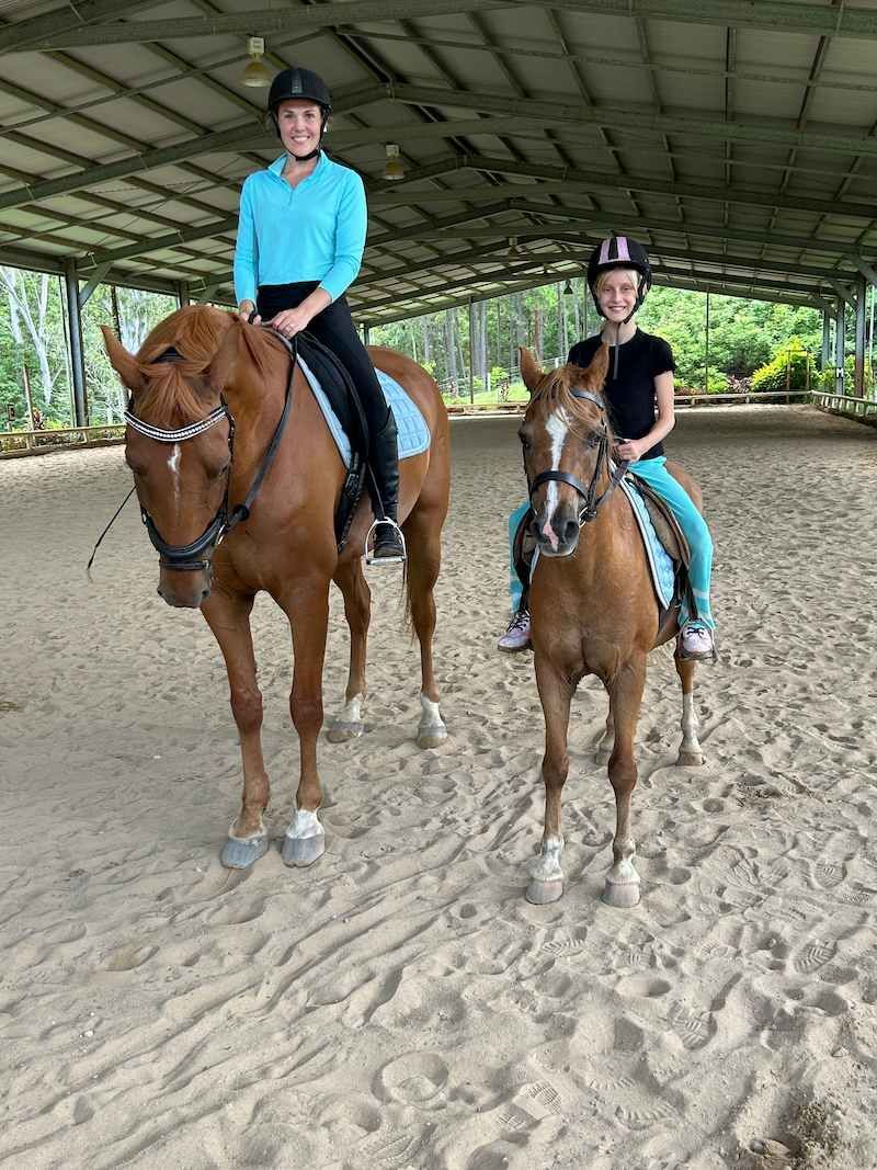 Two People Are Riding Horses in a Dirt Arena — Merrypark Equestrian Centre In Eumundi, QLD