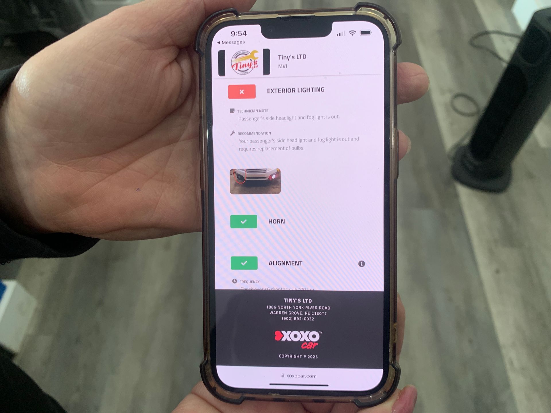 A person is holding a cell phone in their hand. | Tiny's Automotive