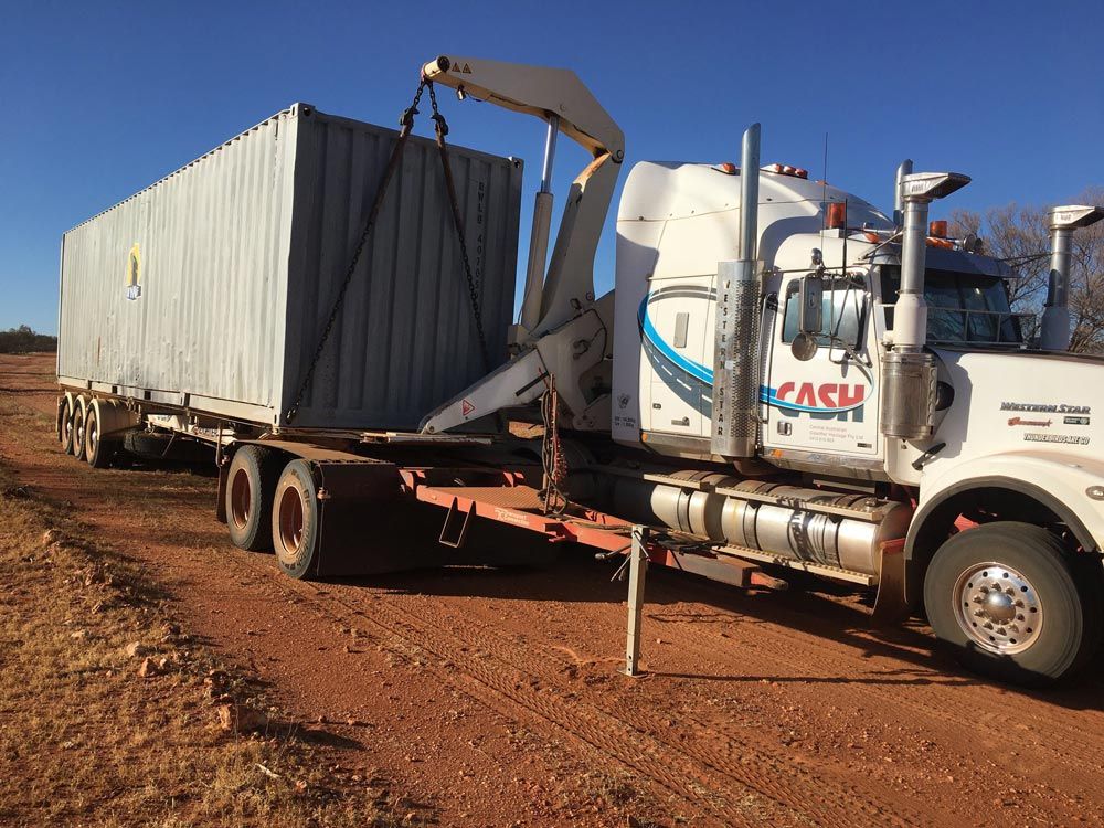 Grey Container Being Loaded Onto the Trailer — Central Australian Sidelifter Haulage In Braitling NT