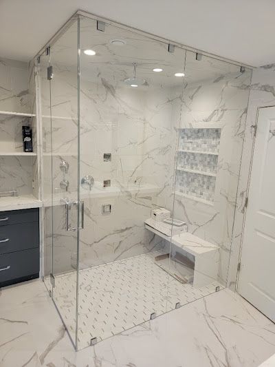 A bathroom with a walk in shower and a bench.