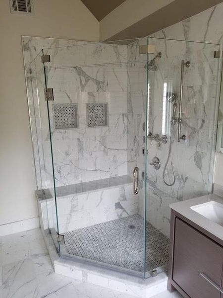 A bathroom with a walk in shower and a sink.