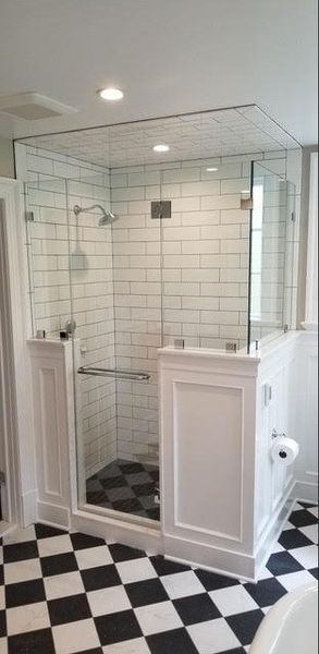 A bathroom with a walk in shower and a checkered floor.