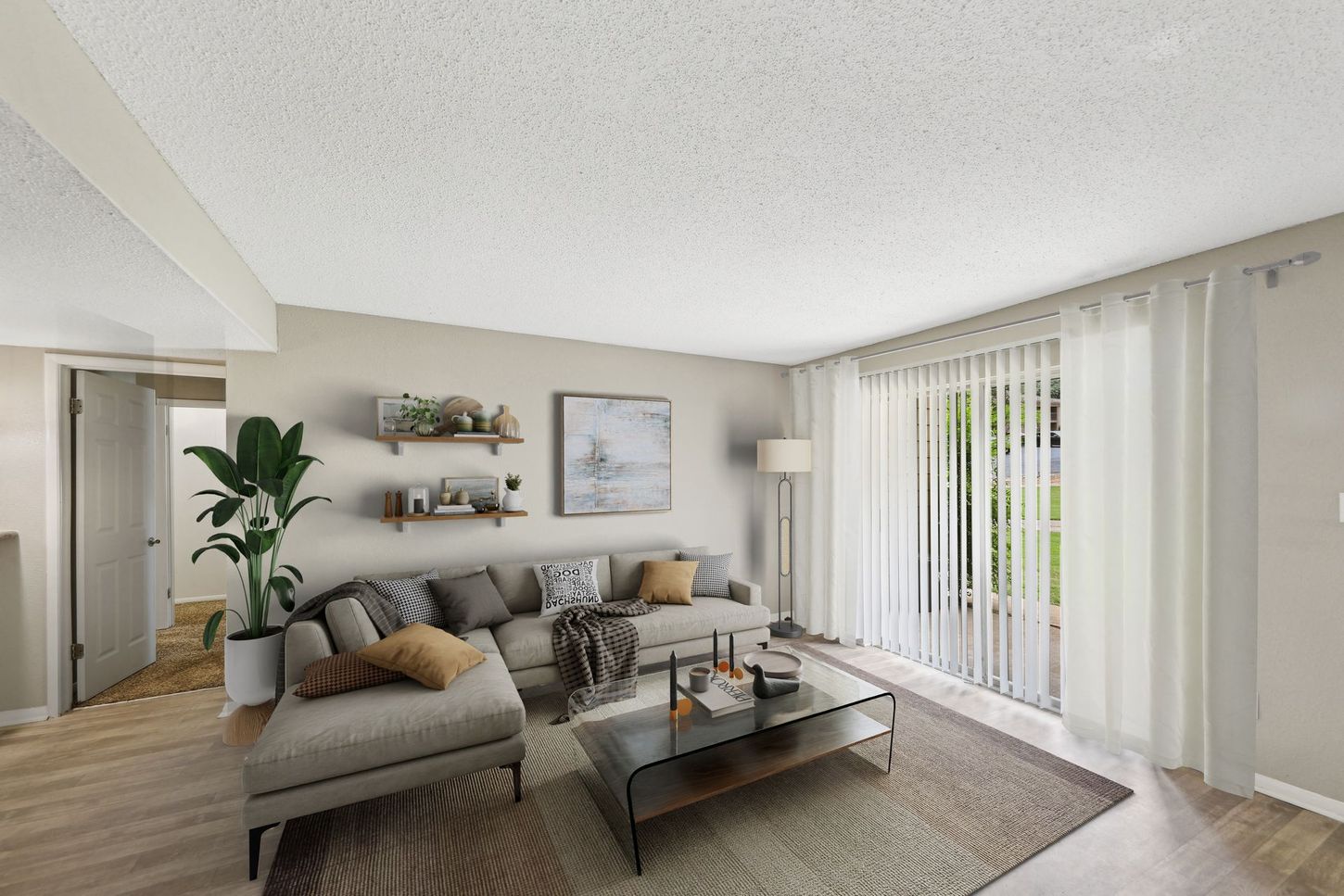A living room with a couch , coffee table , and sliding glass doors.