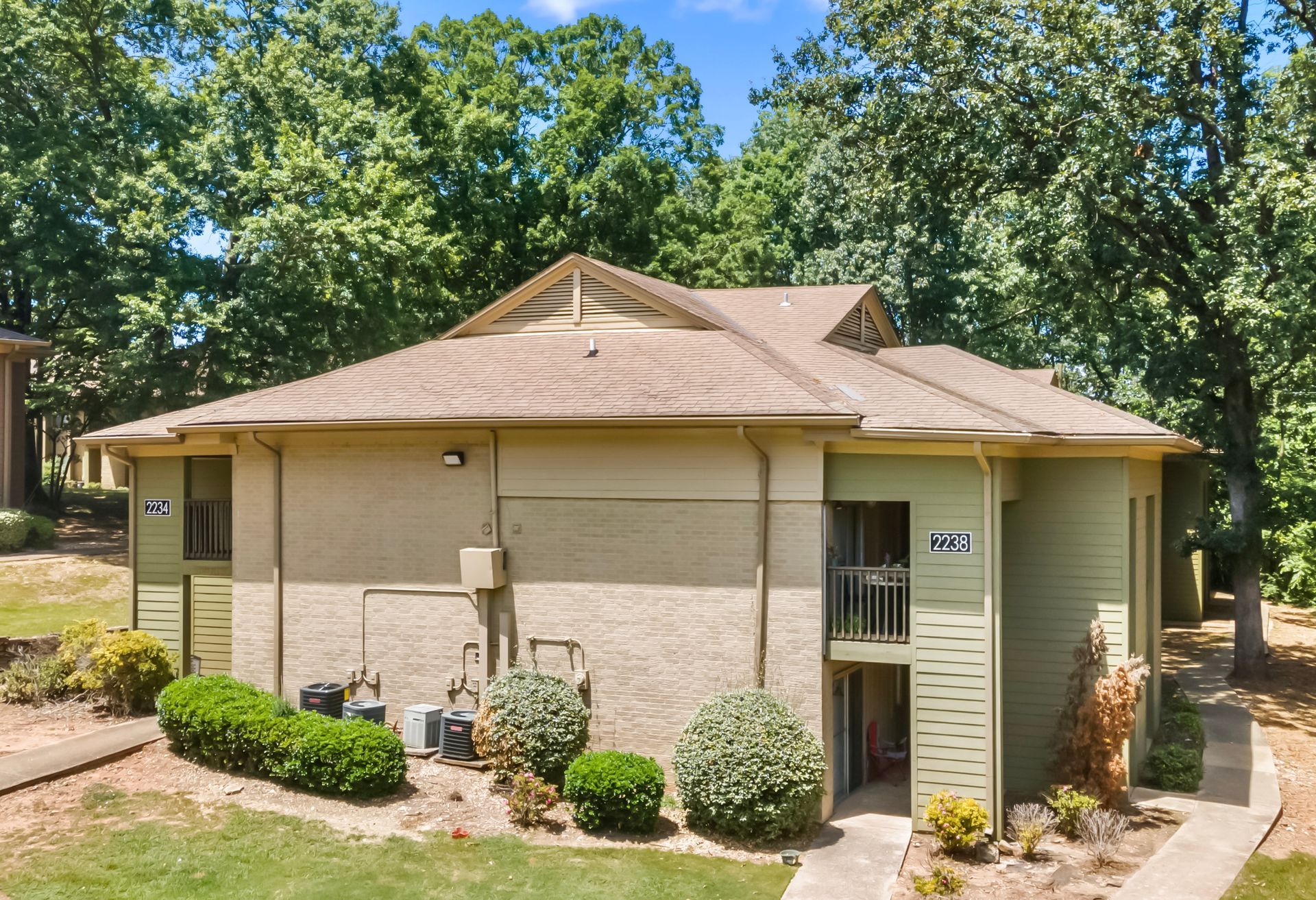 An aerial view of a apartment building with trees in the background
