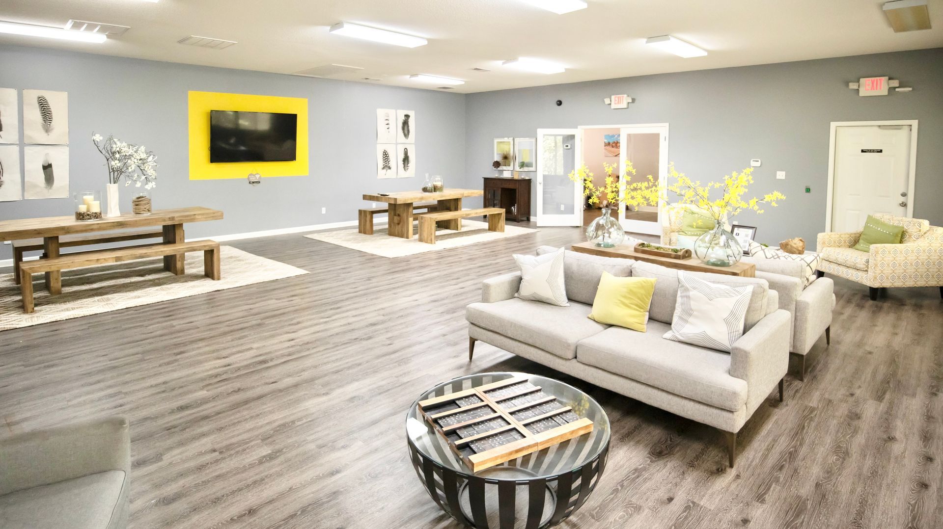 A living room with a couch , chairs , tables and a television.