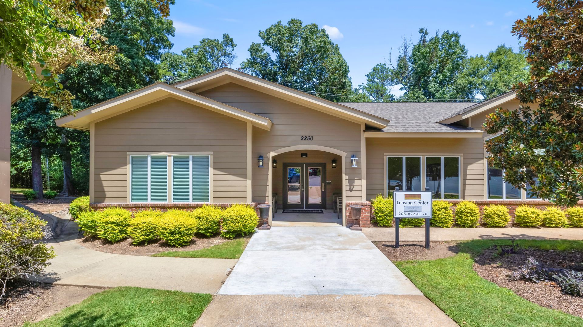 A house with a walkway leading to it and a sign in front of it.