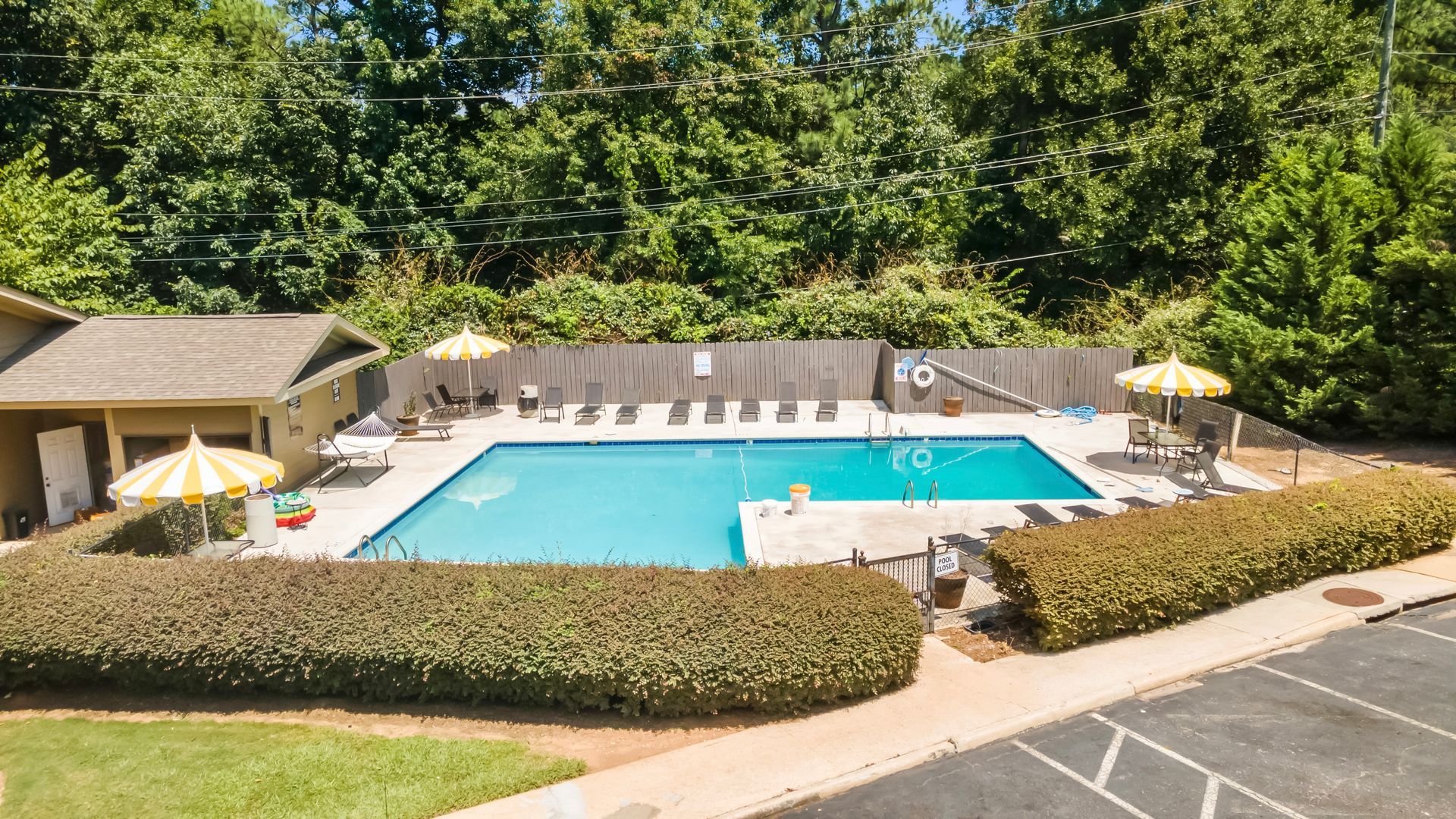 An aerial view of a large swimming pool surrounded by umbrellas and chairs.