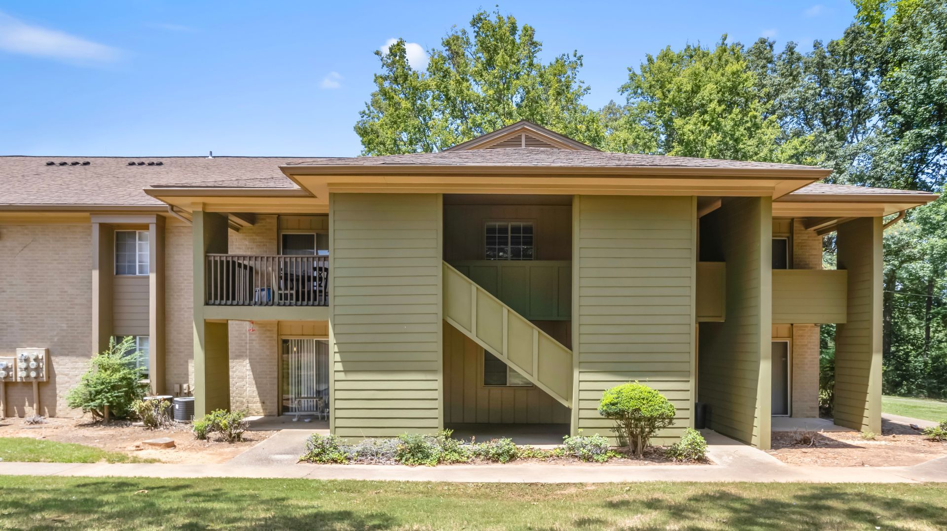 A large apartment building with stairs leading up to the second floor.