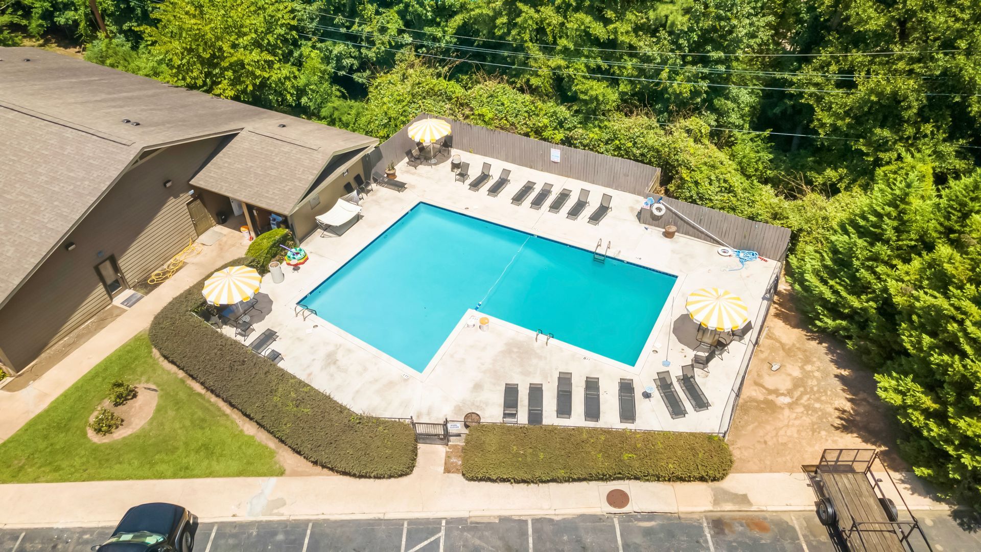 An aerial view of a large swimming pool surrounded by umbrellas and chairs.