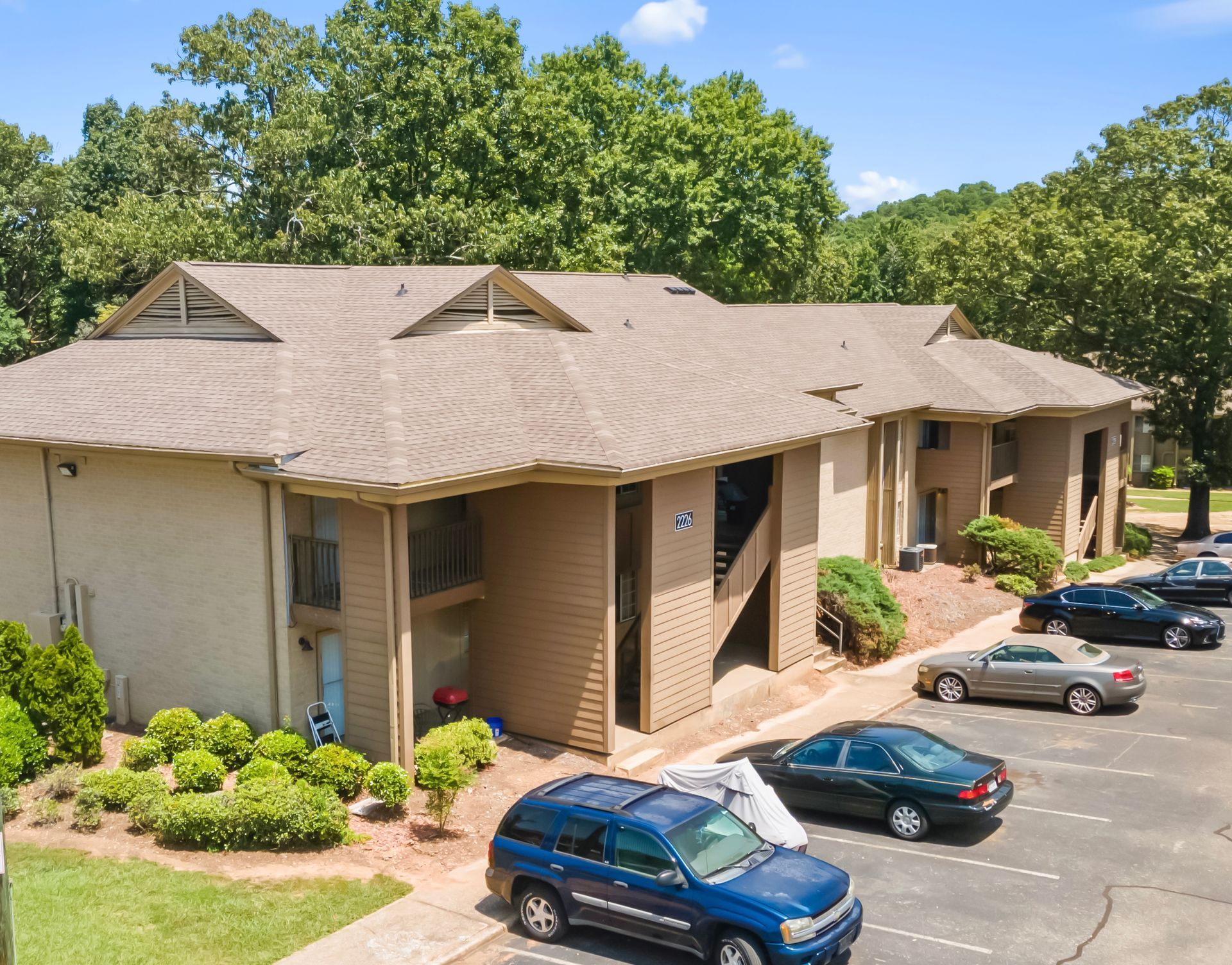 A large apartment building with cars parked in front of it
