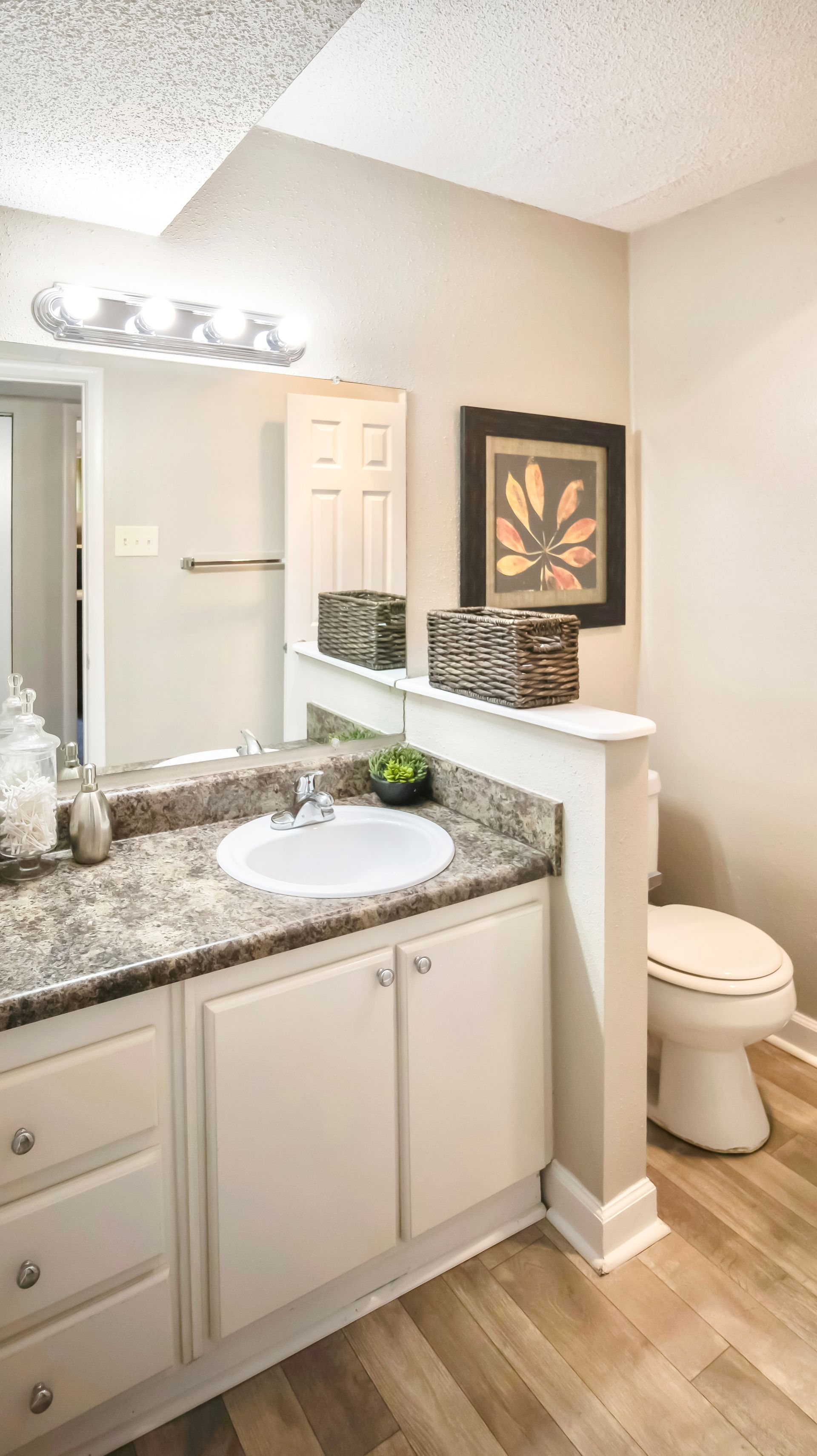 A bathroom with a sink , toilet and mirror.