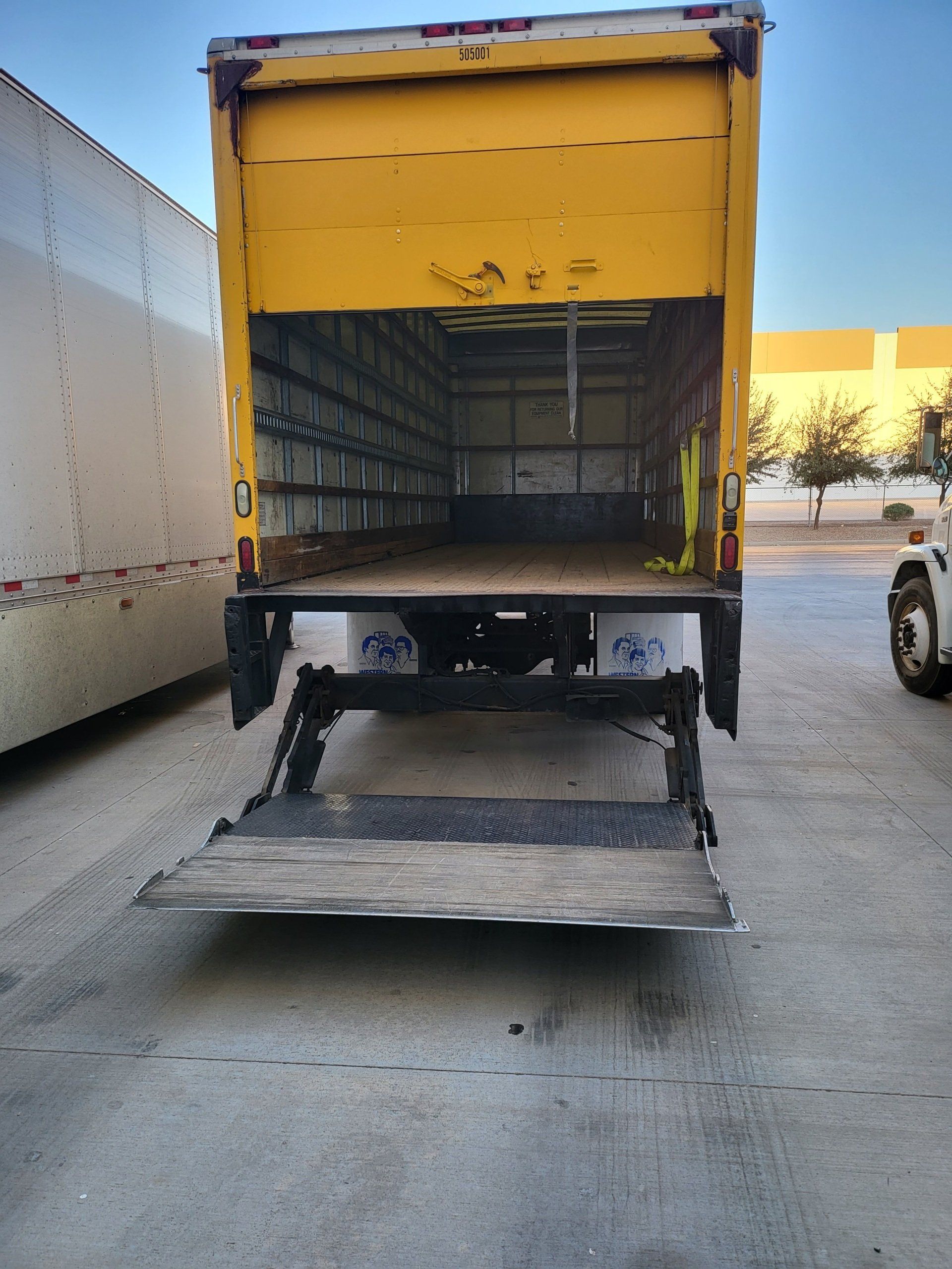 Lowered liftgate on yellow Green Valley box truck.
