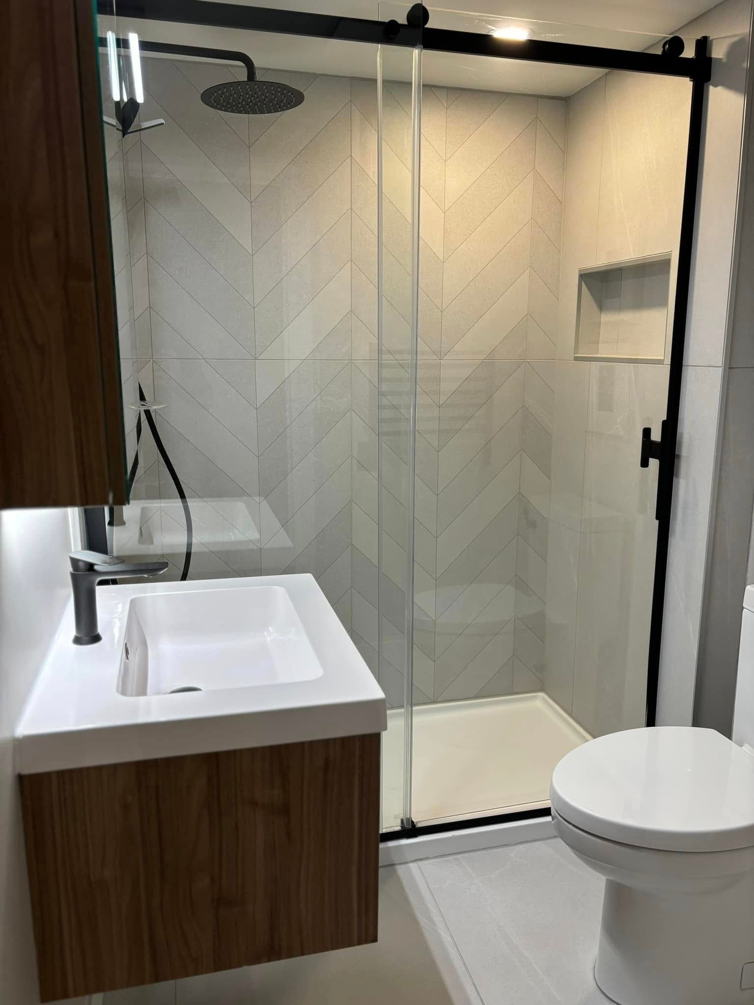 Une salle de bain avec lavabo, WC et douche.