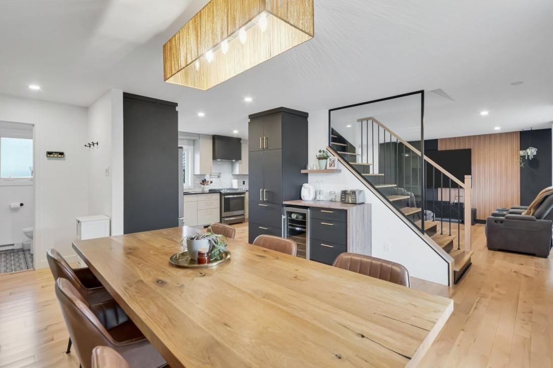 Une salle à manger avec une longue table en bois et des chaises