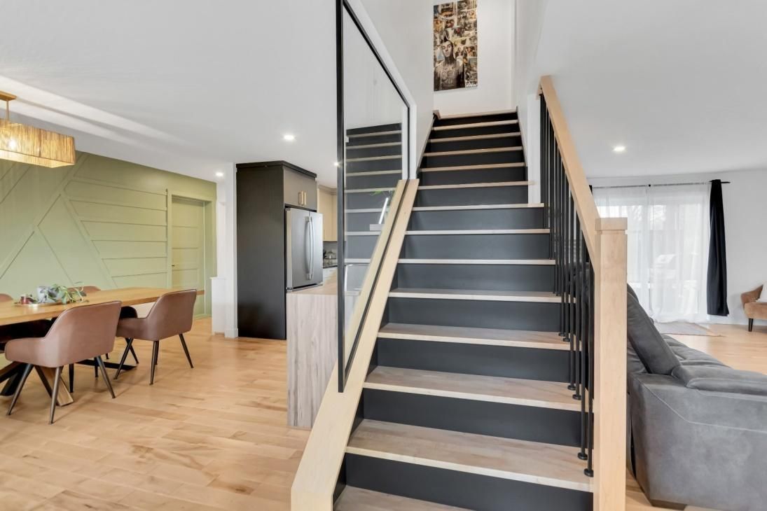 Un salon avec un escalier menant au deuxième étage.