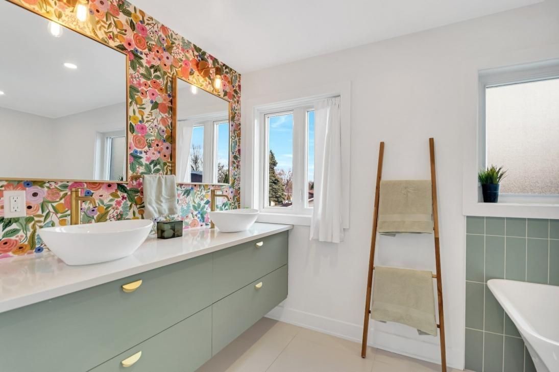 Une salle de bain avec deux lavabos, un miroir et une échelle.