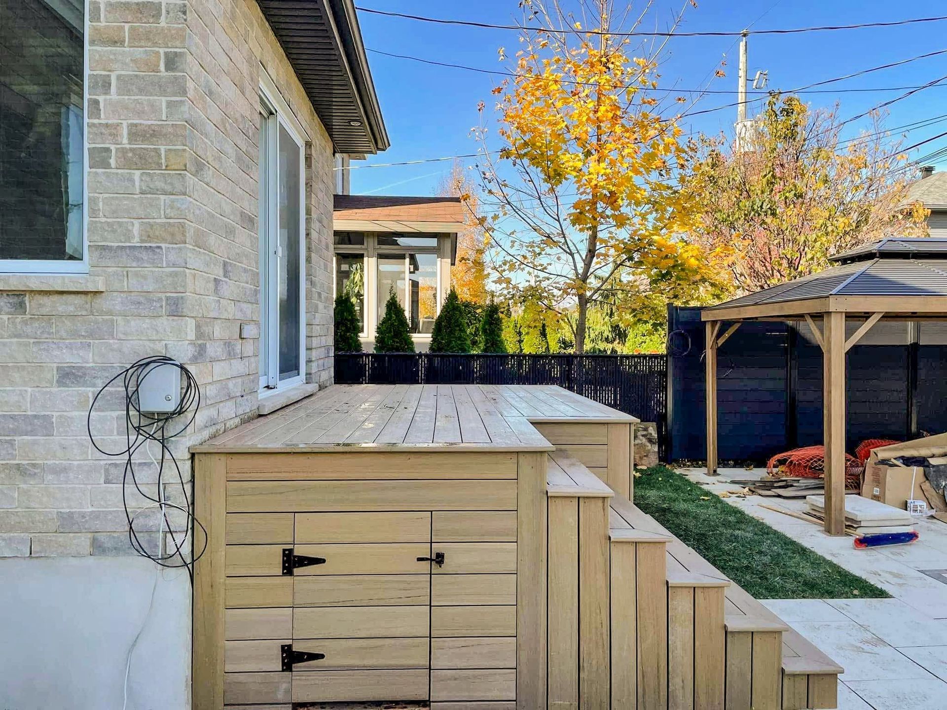 Une terrasse en bois avec des escaliers qui y mènent se trouve dans l'arrière-cour d'une maison.