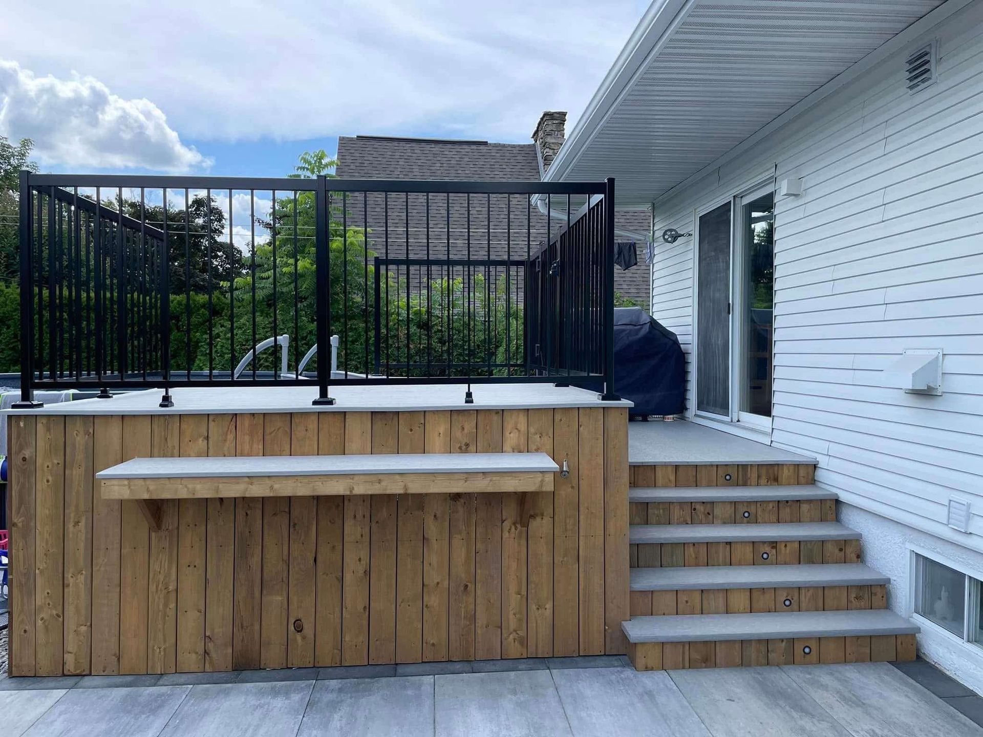 Il y a une terrasse en bois avec des escaliers qui y mènent.