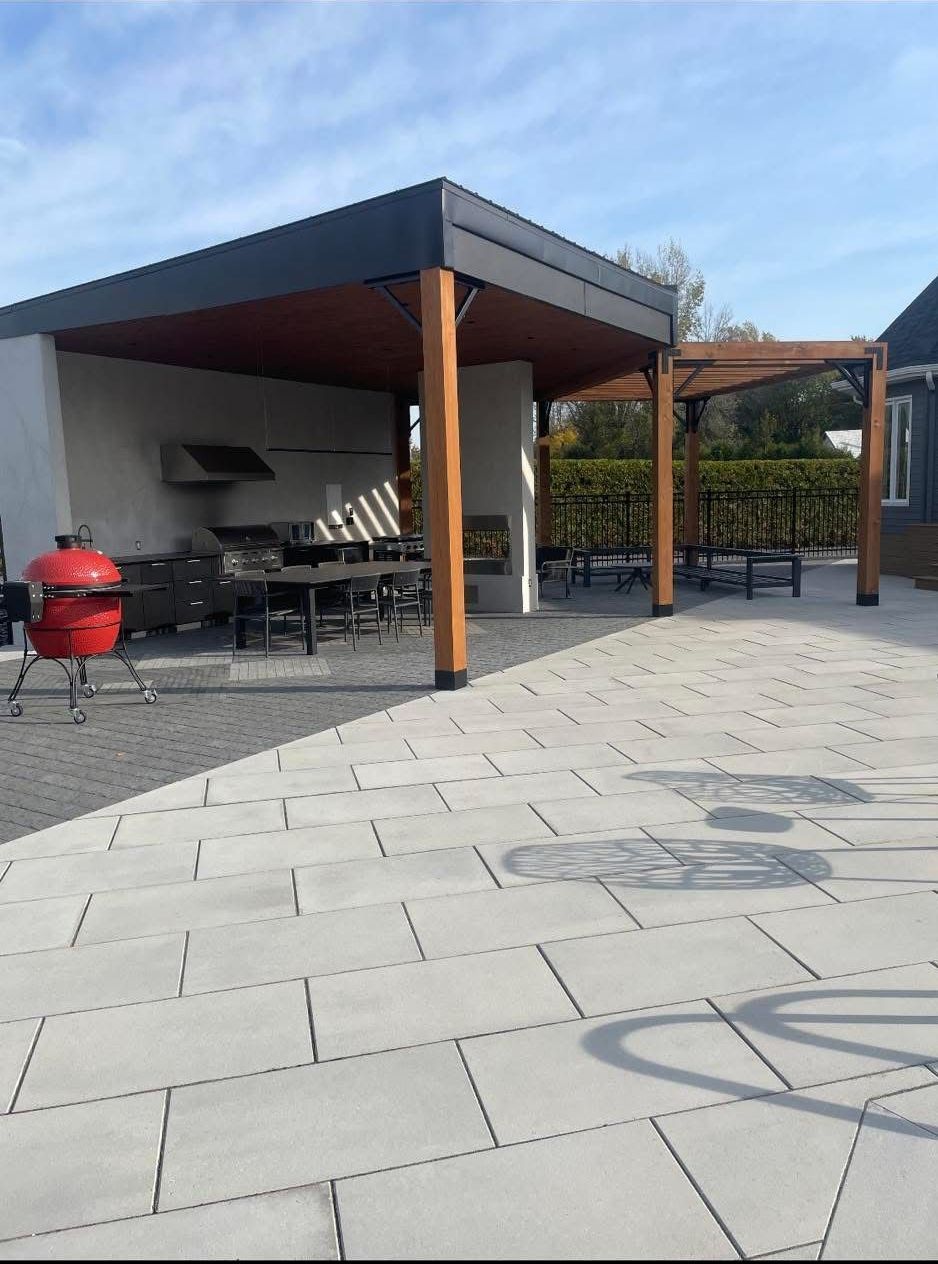 Un patio avec une pergola et un barbecue