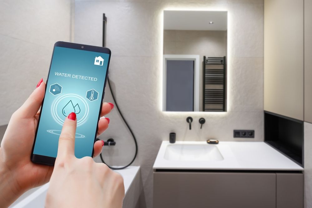 A woman is holding a smart phone in a bathroom.