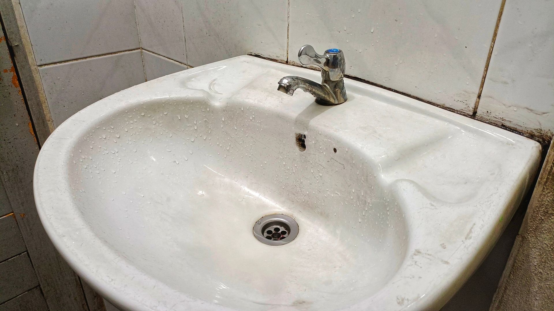 A white sink with a faucet in a bathroom.