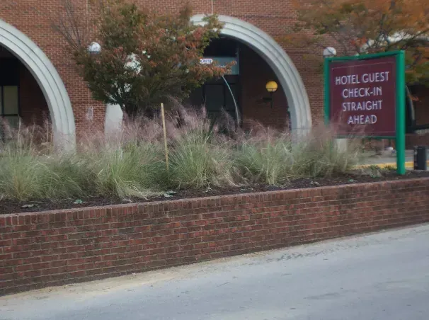 Hotel entrance with arched brick facade and sign: 
