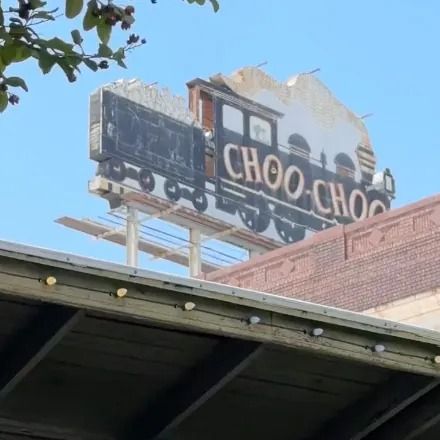 Sign for a restaurant featuring a train, reading 