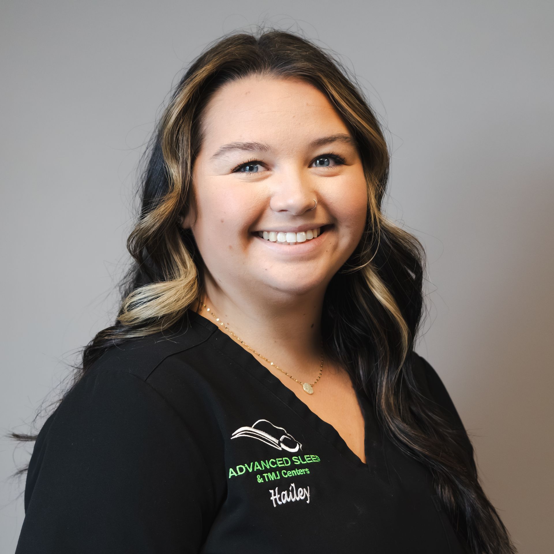 A woman in a black shirt is smiling for the camera.