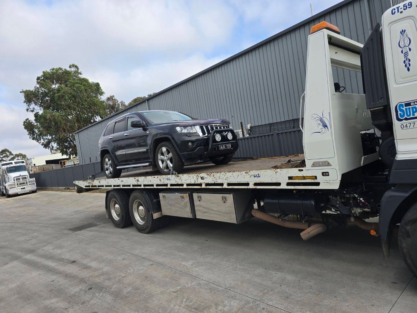 A black suv is sitting on top of a flatbed tow truck — Ballarat Supatilt in Delacombe, VIC