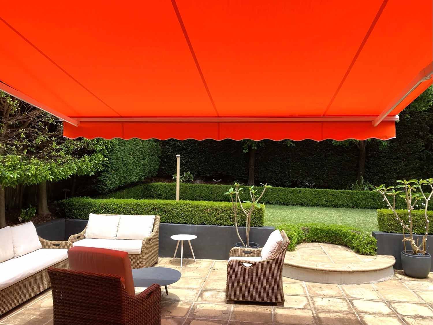 A patio with chairs and an orange awning | Sydney, NSW | Sunmaster Australia