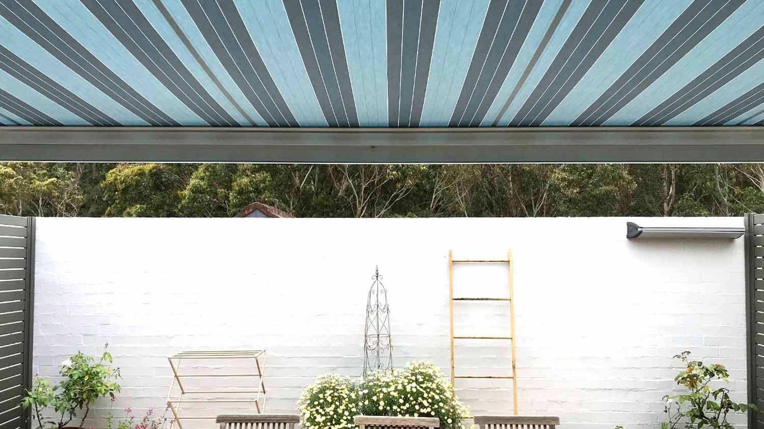 A blue and grey striped awning over a white wall | Sydney, NSW | Sunmaster Australia