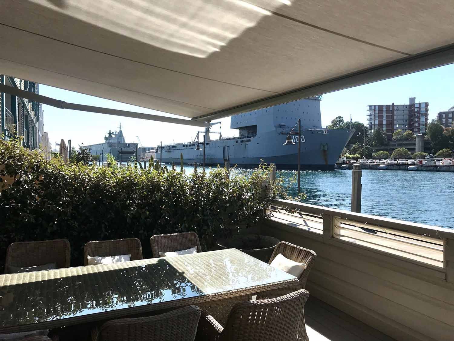 A table and chairs on a deck overlooking water | Sydney, NSW | Sunmaster Australia