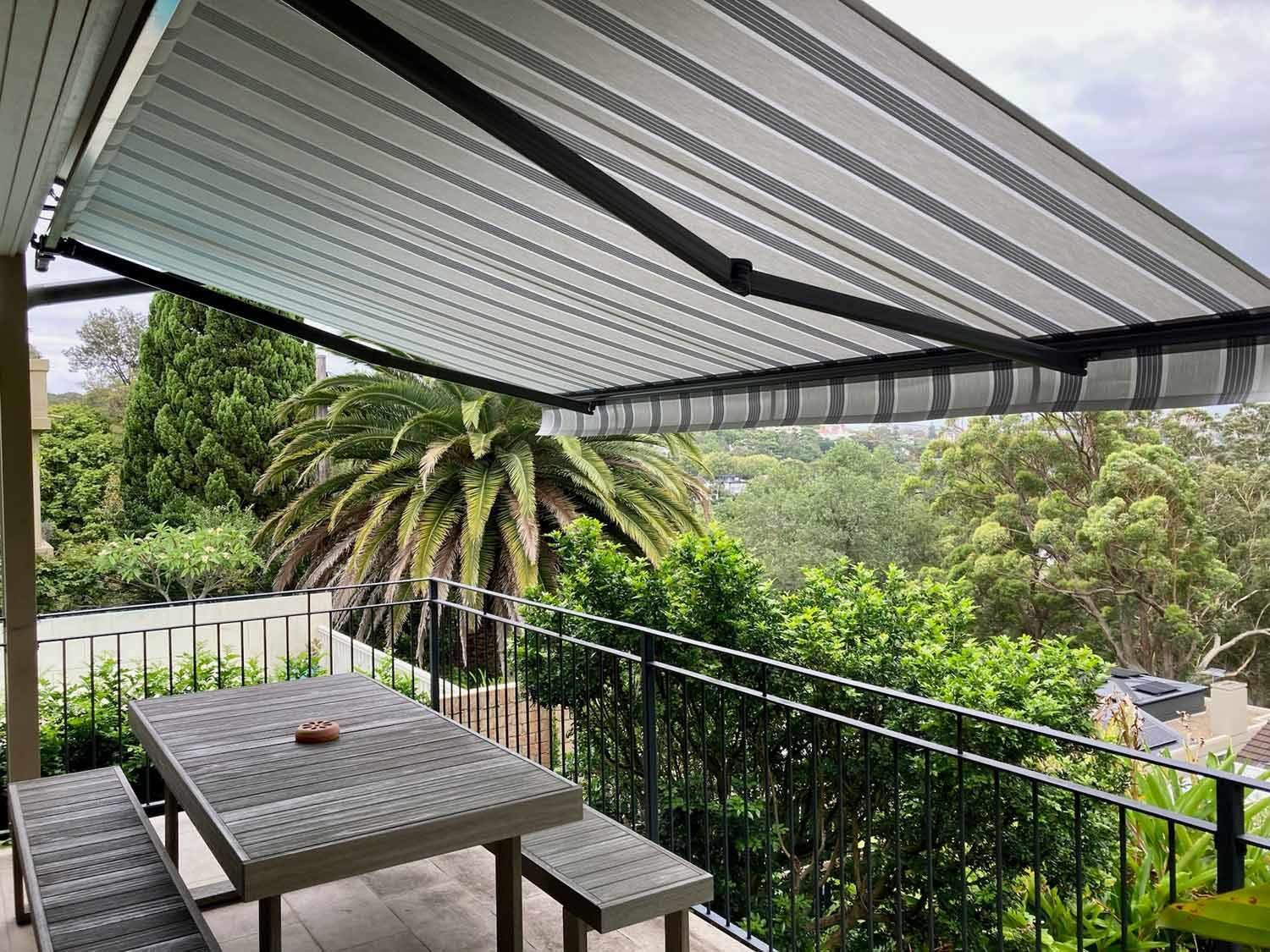 A table and chairs under the stripe open awning | Sydney, NSW | Sunmaster Australia