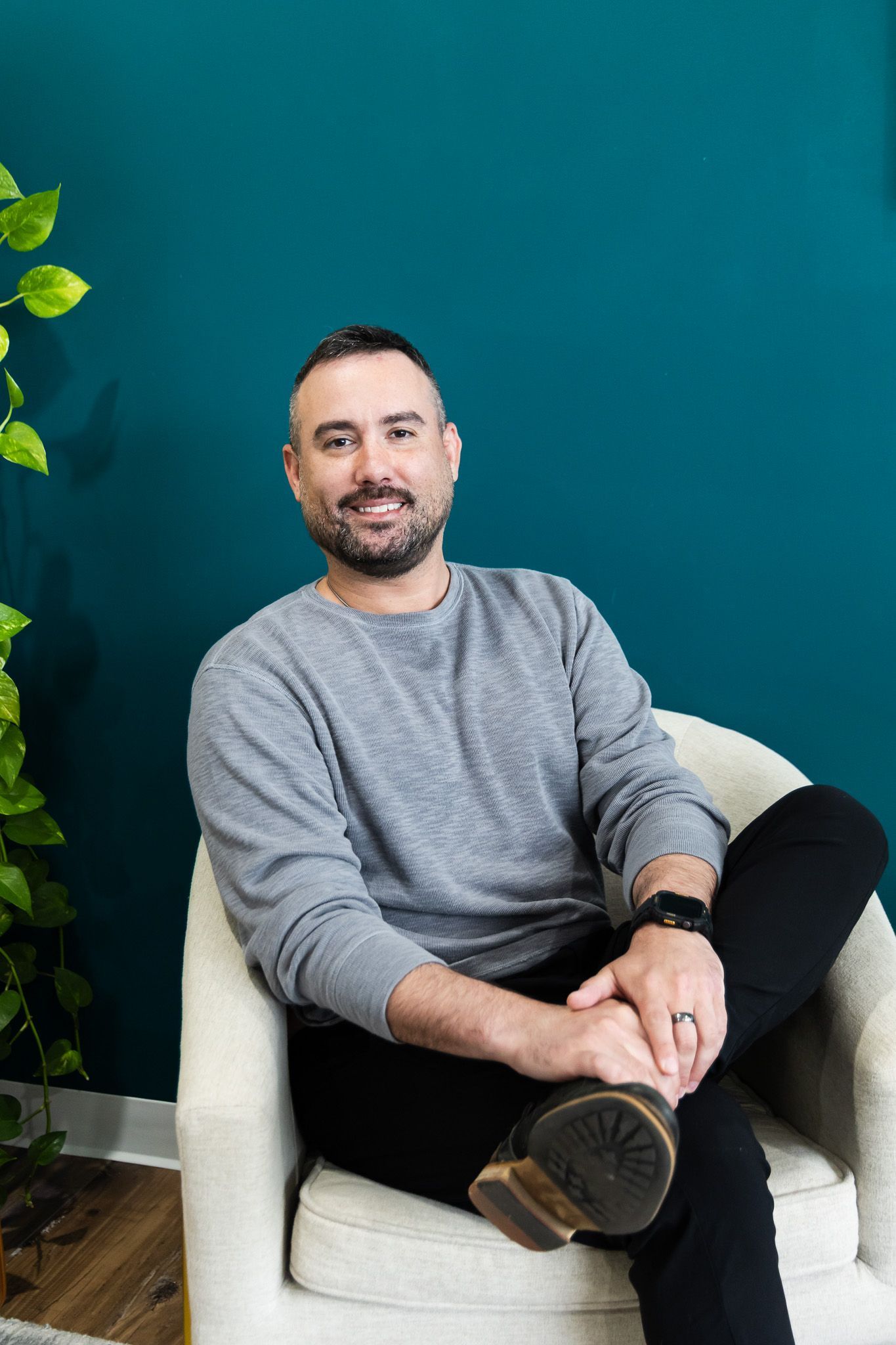 A woman is sitting at a desk with her hands folded.