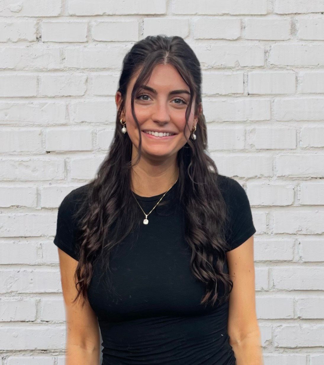 A woman with long black hair is smiling and looking at the camera.